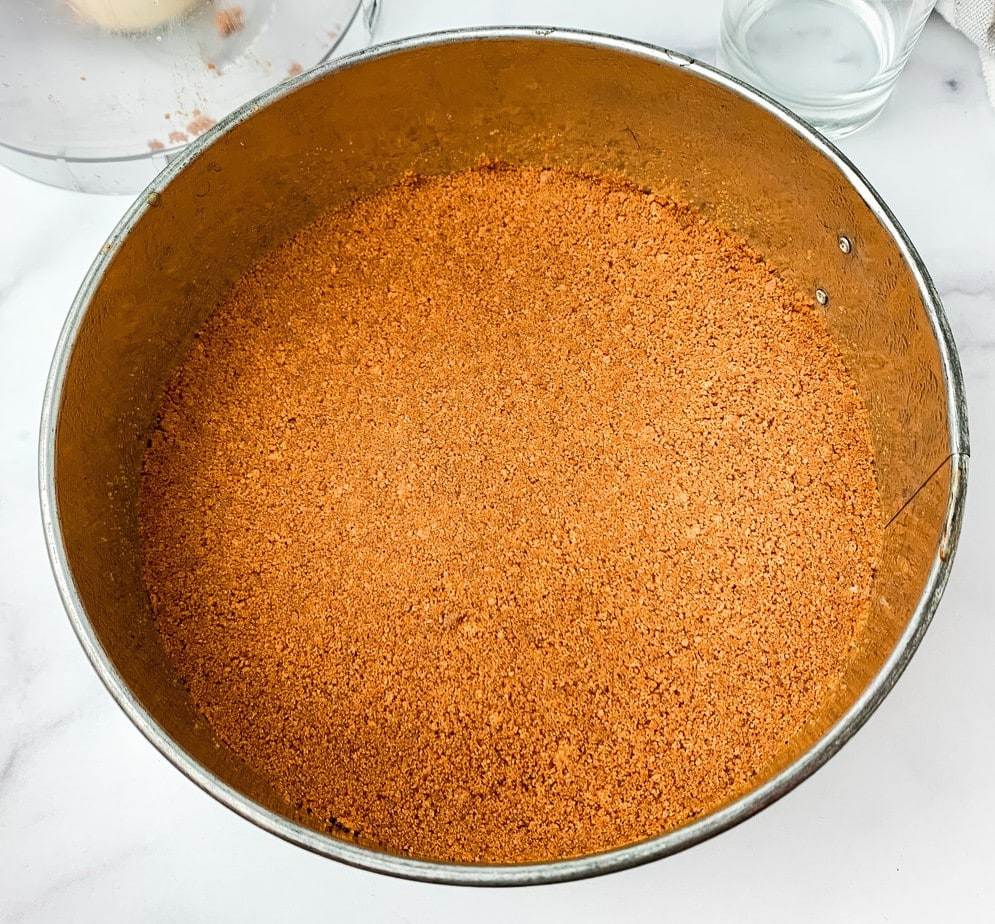 A view of the Biscoff cookie crumbs pressed into a springform pan
