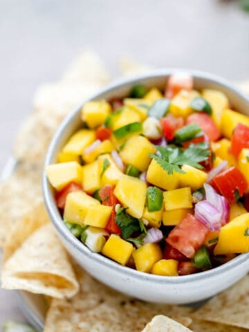 A side of mango pico de gallo in a bowl with chips