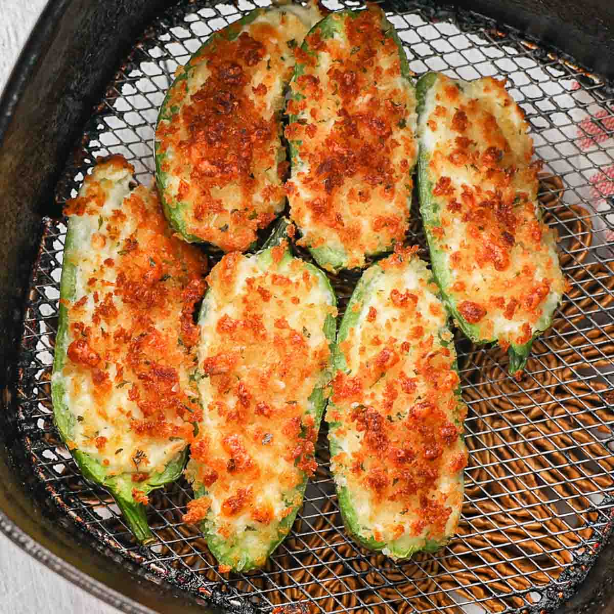 Jalapeno Poppers fully cooked and golden brown in the air fryer basket