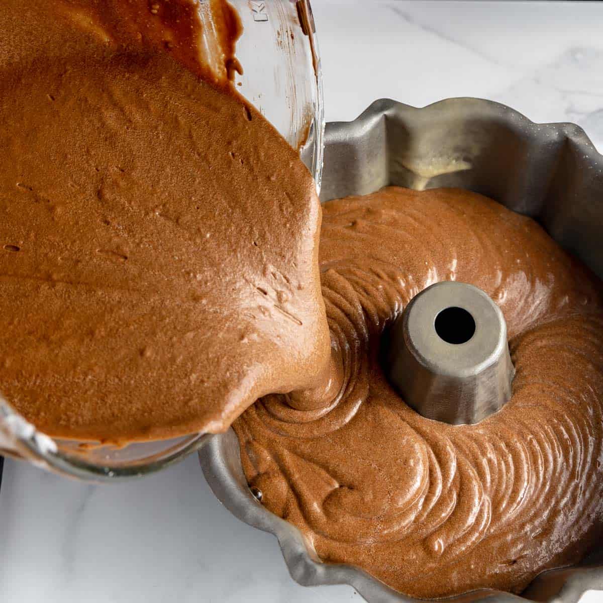 Chocolate cake batter poured into a bundt pan