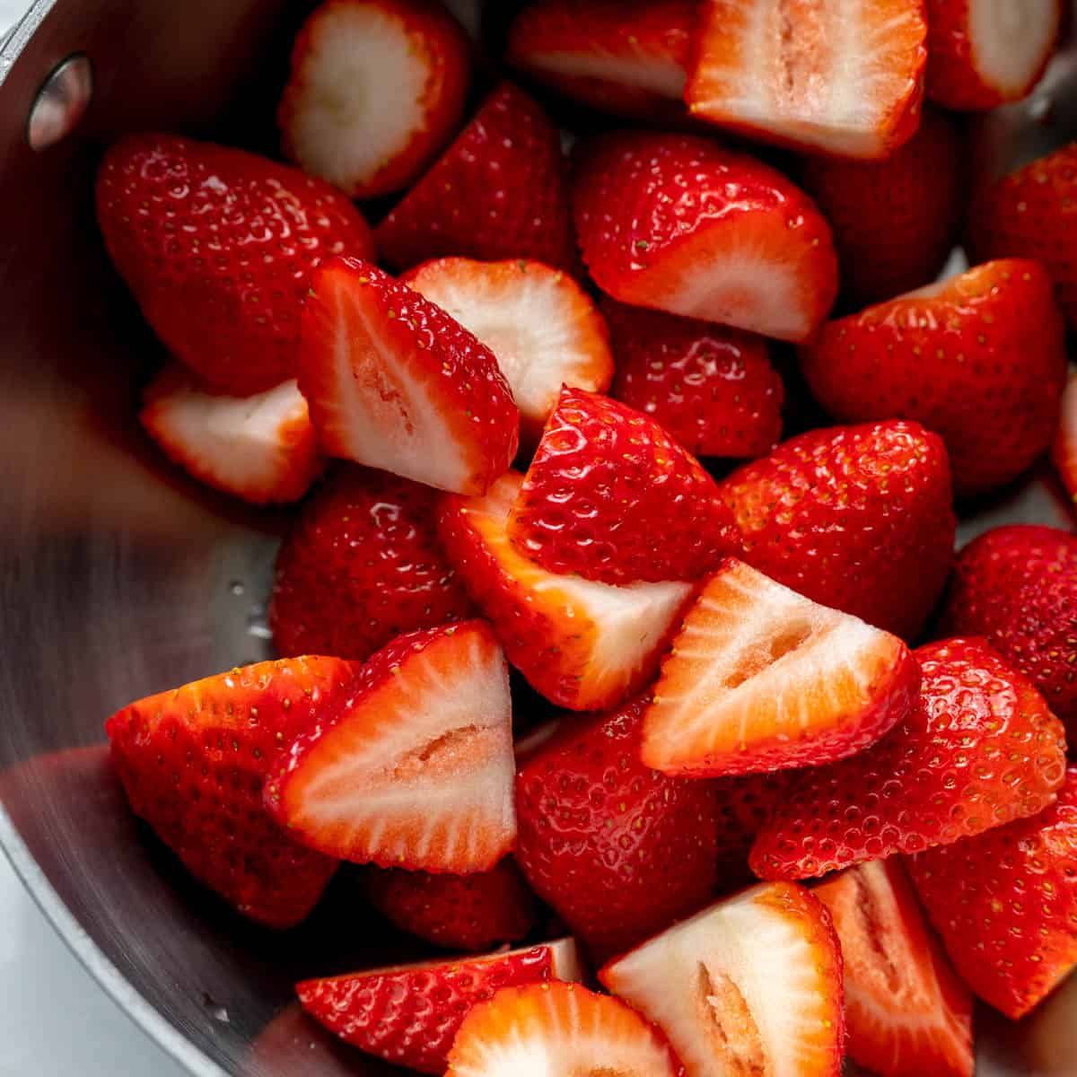A close up of halved strawberries in a pot