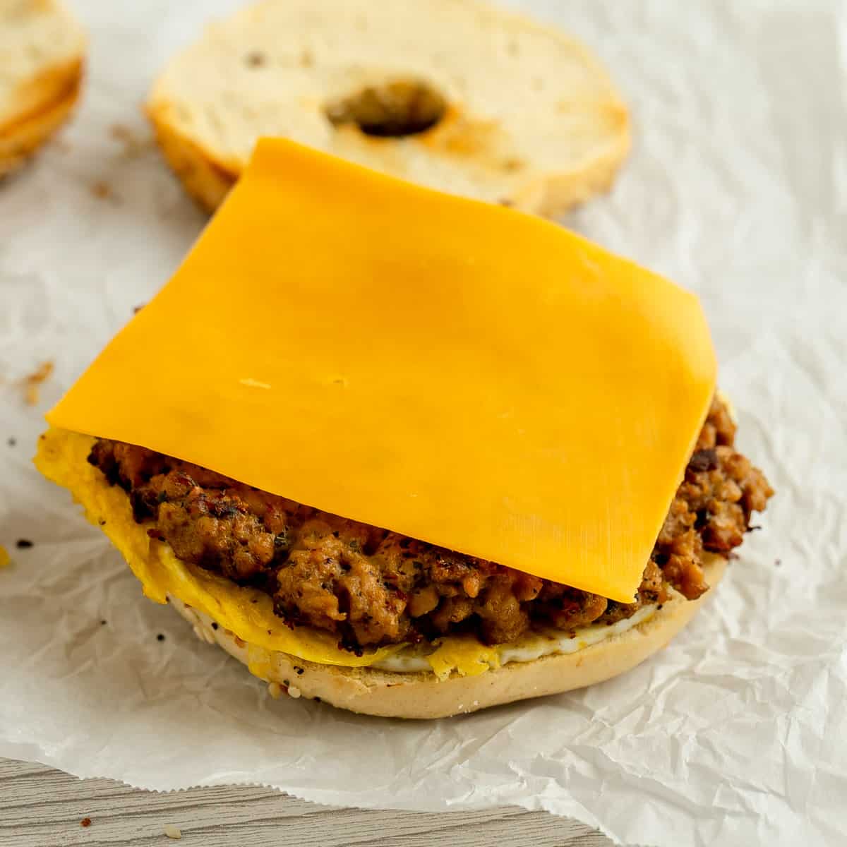 A slice of cheese on a sausage patty.
