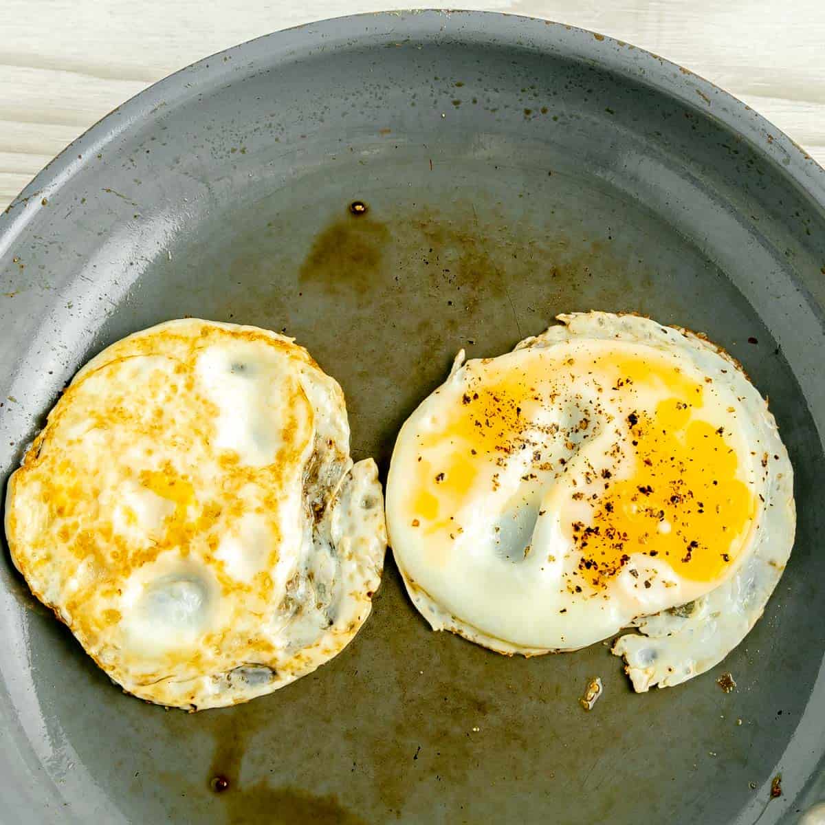 Two eggs frying in a pan.