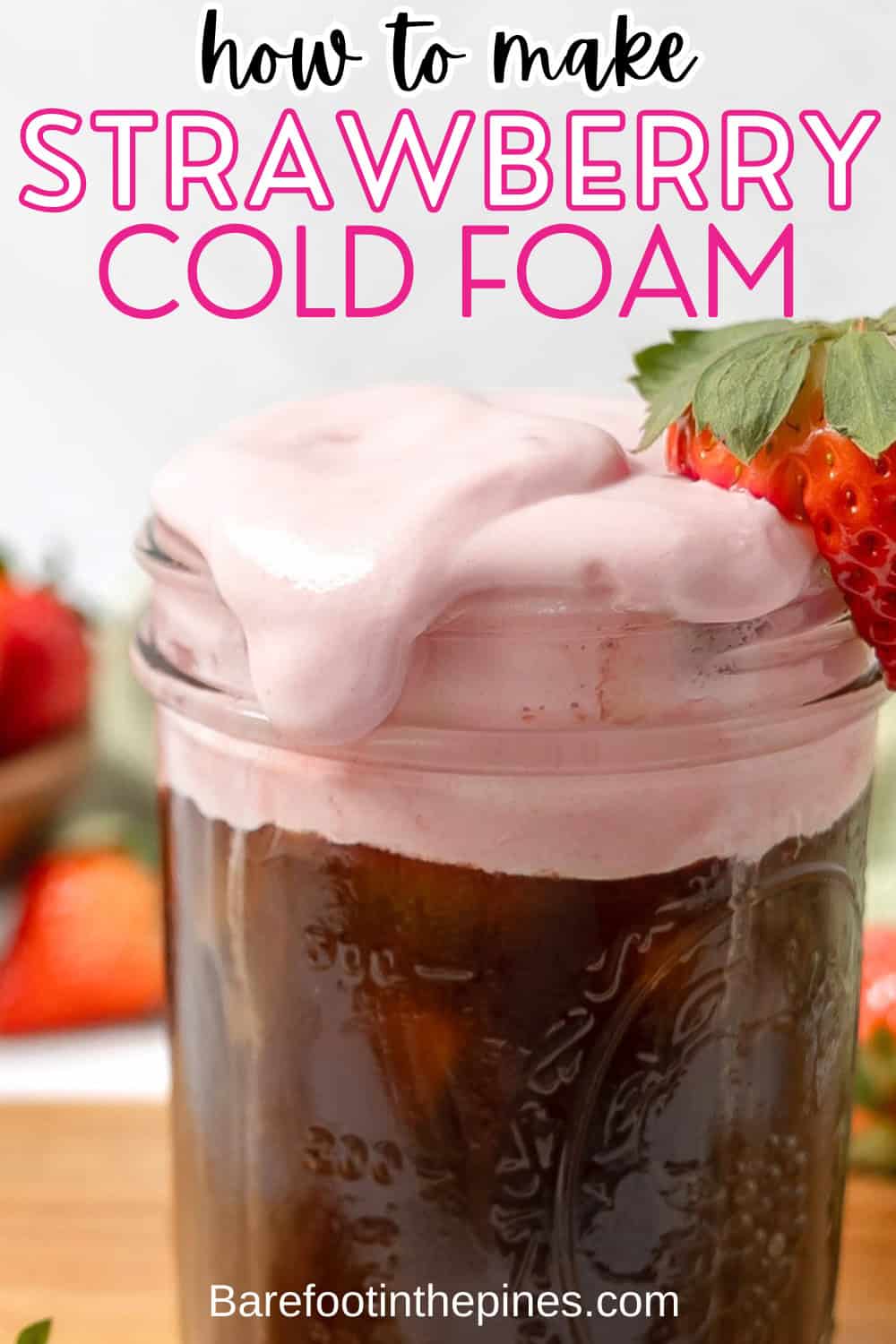 A glass jar of iced coffee topped with creamy Strawberry Cold Foam, garnished with a fresh strawberry, with "how to make strawberry cold foam" text above.
