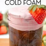Glass jar filled with iced coffee topped with creamy strawberry cold foam, garnished with a fresh strawberry. Text overlay reads "homemade Strawberry Cold Foam.