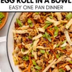 Egg Roll In A Bowl with ground meat, shredded veggies, green onions, and crispy wonton strips cooked in a white pan with wooden utensils. Text overlay describes the easy Egg Roll In A Bowl recipe.