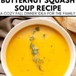 Bowl of creamy roasted butternut squash soup garnished with fresh thyme, with bread and pumpkin seeds on the side. Text overlay describes the soup as an easy, cozy fall dinner recipe.