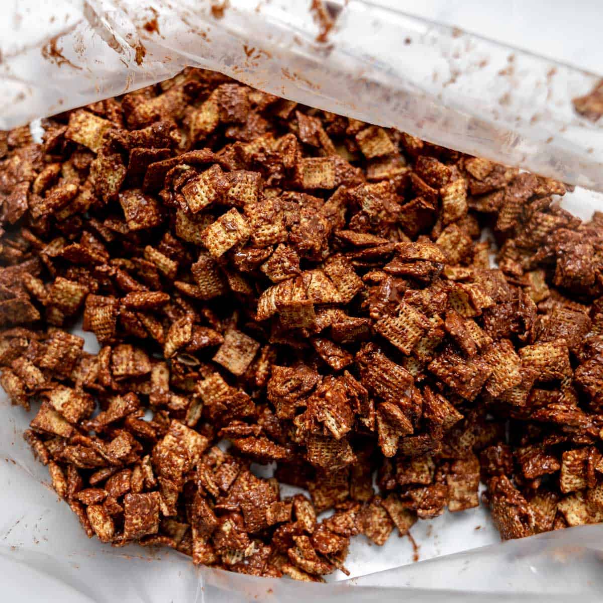 Chocolate-coated cereal squares inside a partially opened plastic bag, viewed from above.